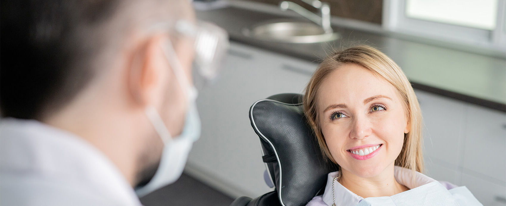 patient in dental chair smiling at dentist